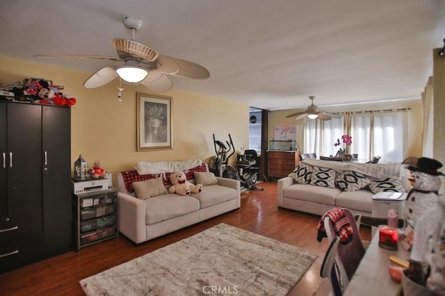 living room with ceiling fan and dark wood-type flooring