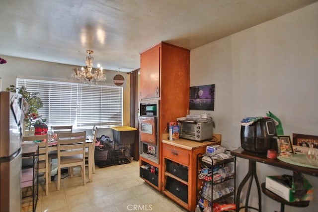 kitchen featuring stainless steel fridge, hanging light fixtures, and a notable chandelier