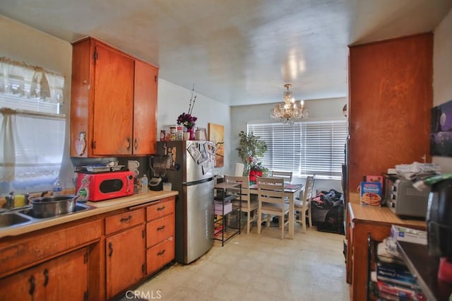 kitchen featuring sink, stainless steel fridge, and a chandelier