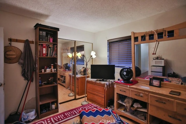 office space featuring a textured ceiling and light hardwood / wood-style flooring