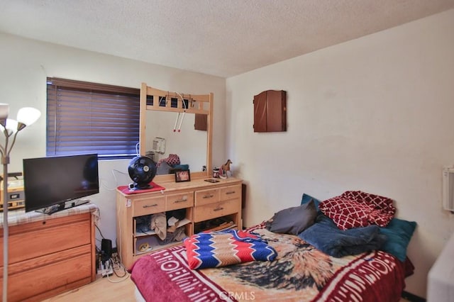 bedroom featuring hardwood / wood-style flooring and a textured ceiling