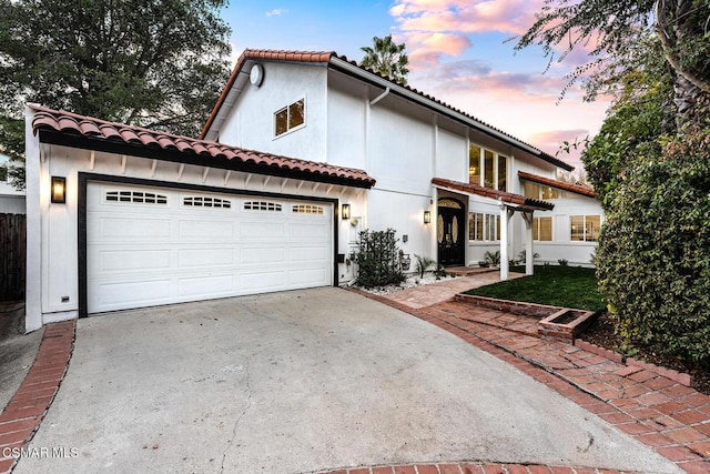 mediterranean / spanish-style house with a garage