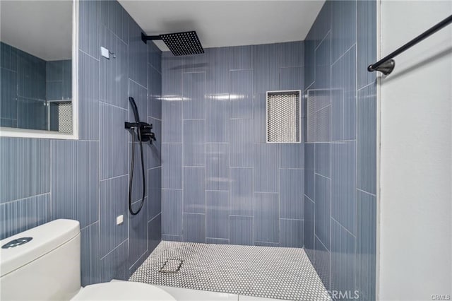 bathroom with toilet and a tile shower