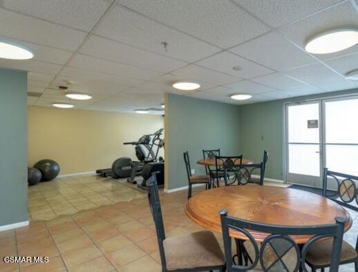 tiled dining space with a paneled ceiling