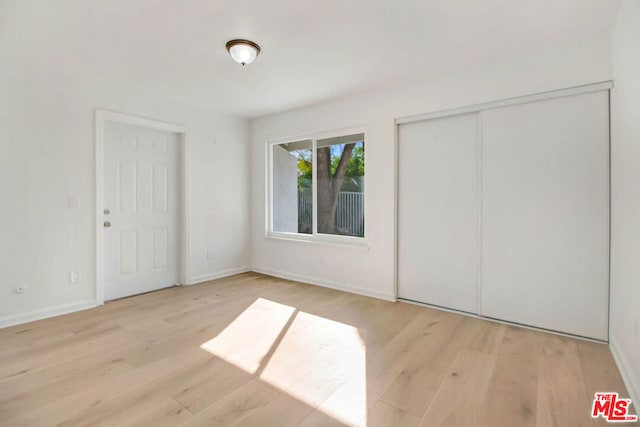 unfurnished bedroom featuring a closet and light hardwood / wood-style flooring