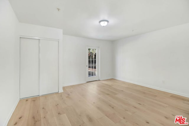 unfurnished bedroom featuring a closet and light wood-type flooring