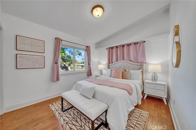 bedroom featuring light hardwood / wood-style flooring and lofted ceiling