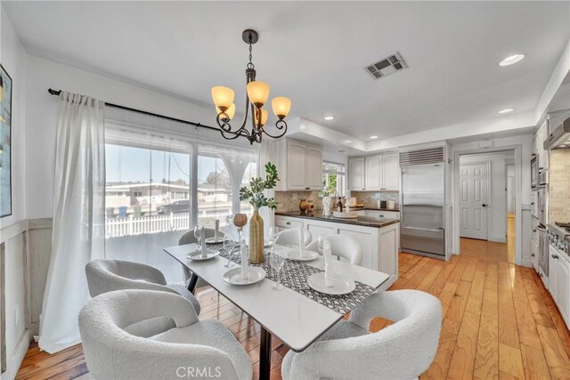 dining space featuring a notable chandelier and light hardwood / wood-style flooring