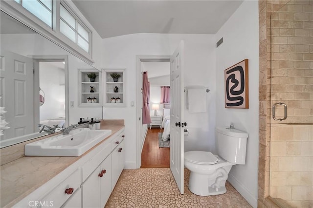 bathroom with an enclosed shower, vanity, and toilet