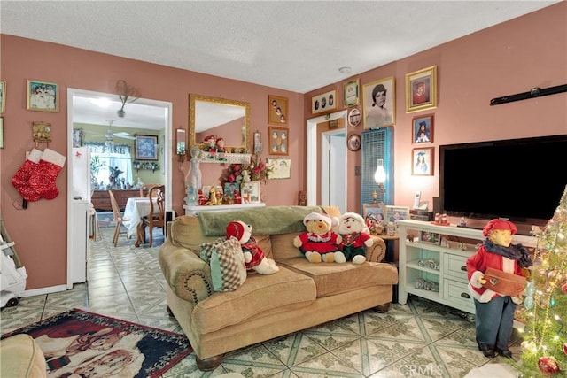 living room with ceiling fan and a textured ceiling