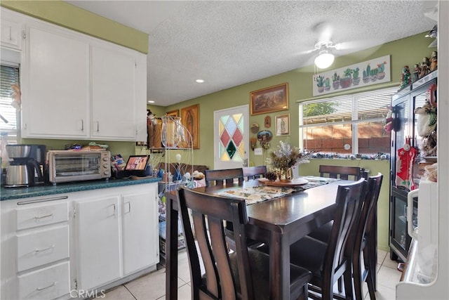 tiled dining area featuring a textured ceiling and ceiling fan