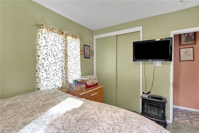 tiled bedroom with a textured ceiling and a closet