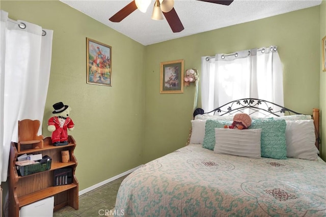 bedroom with ceiling fan and dark tile patterned flooring