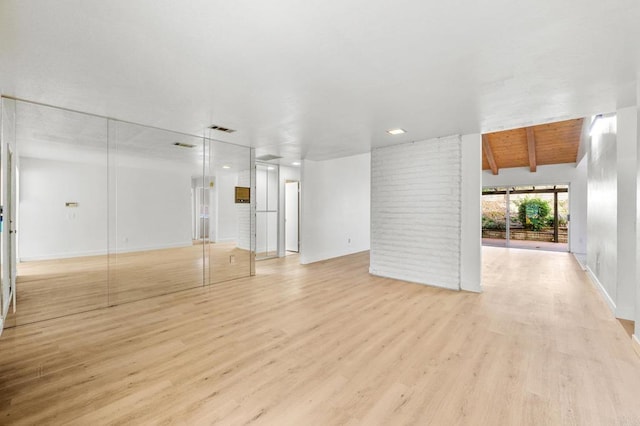 unfurnished living room with vaulted ceiling with beams, wood ceiling, and light hardwood / wood-style floors