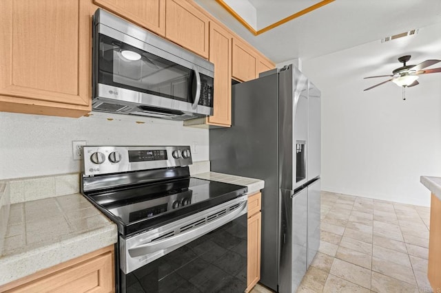 kitchen with ceiling fan, light brown cabinetry, light tile patterned flooring, and stainless steel appliances