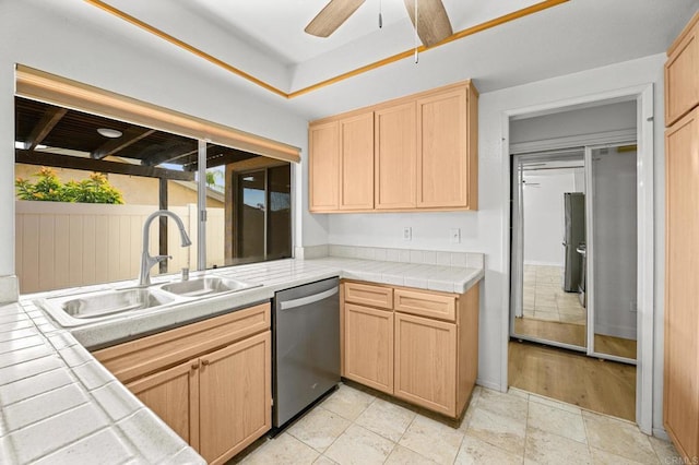 kitchen with light brown cabinetry, sink, stainless steel dishwasher, and tile countertops