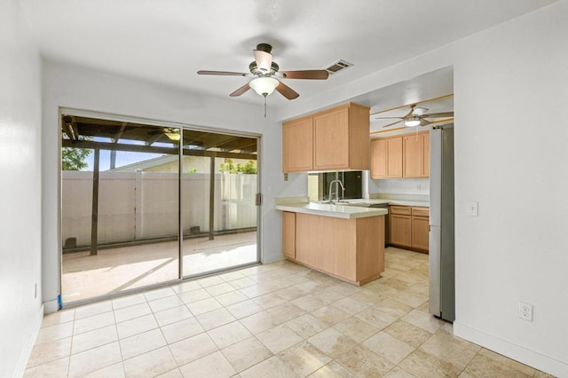 kitchen with light brown cabinets, sink, stainless steel fridge, kitchen peninsula, and ceiling fan