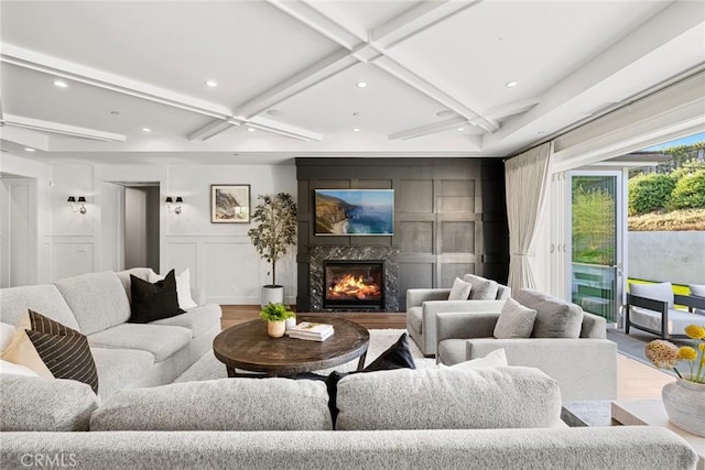 living room featuring beam ceiling, a premium fireplace, and coffered ceiling