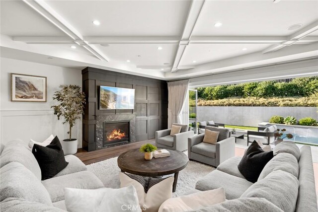 living room featuring a fireplace, beamed ceiling, and coffered ceiling