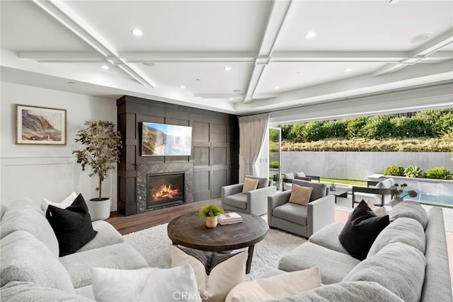 living room with wood-type flooring, coffered ceiling, and a high end fireplace