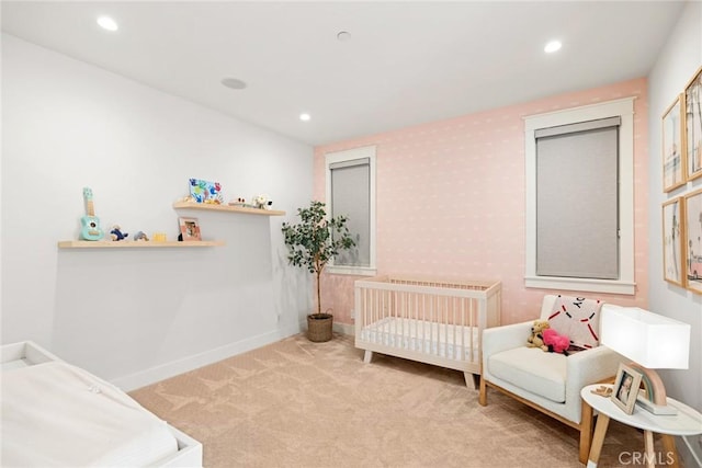 bedroom featuring a crib, radiator, and light carpet