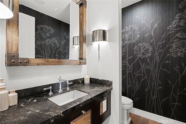 bathroom with wood-type flooring, toilet, and vanity