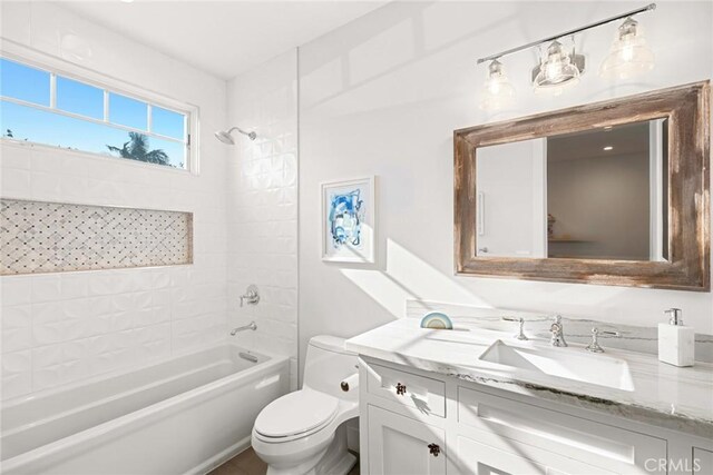 full bathroom with toilet, tiled shower / bath combo, and vanity