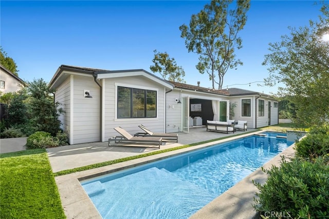 back of property featuring outdoor lounge area and a patio