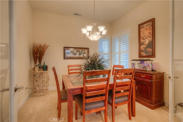 carpeted dining space featuring a chandelier