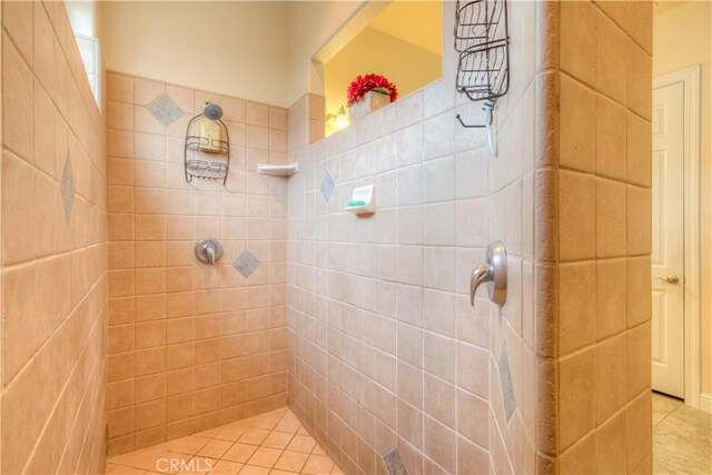 bathroom featuring tiled shower and tile patterned flooring