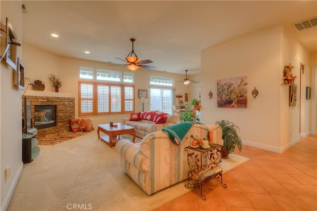 living room with ceiling fan and a fireplace