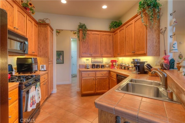 kitchen with sink, stainless steel gas range, tile countertops, and light tile patterned flooring