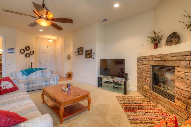 living room with light carpet, ceiling fan, and a fireplace