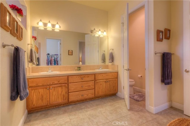 bathroom featuring toilet, tile patterned floors, and vanity