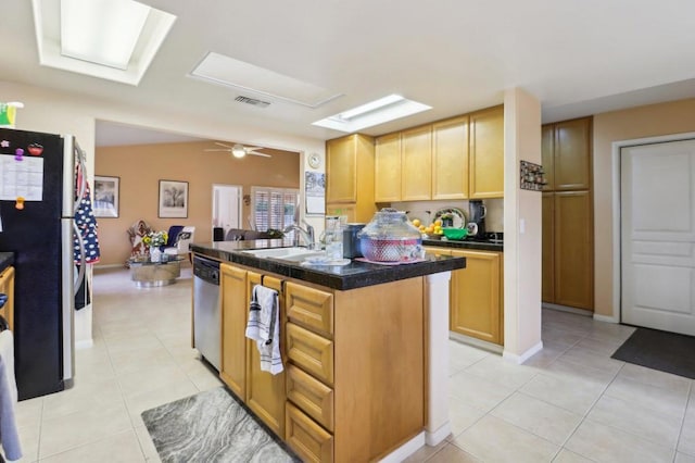 kitchen with stainless steel appliances, light brown cabinetry, sink, a kitchen island with sink, and light tile patterned floors