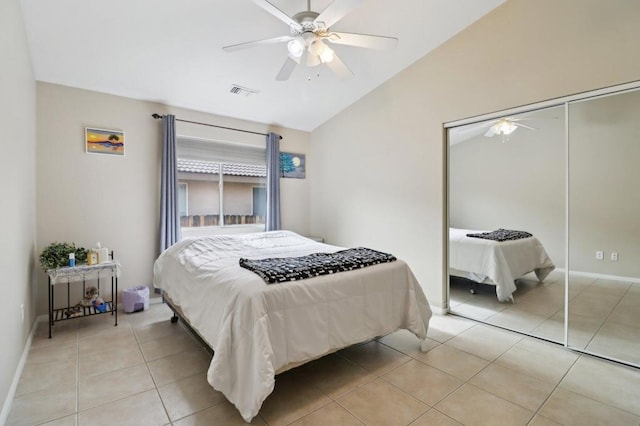 bedroom with ceiling fan, light tile patterned floors, a closet, and lofted ceiling