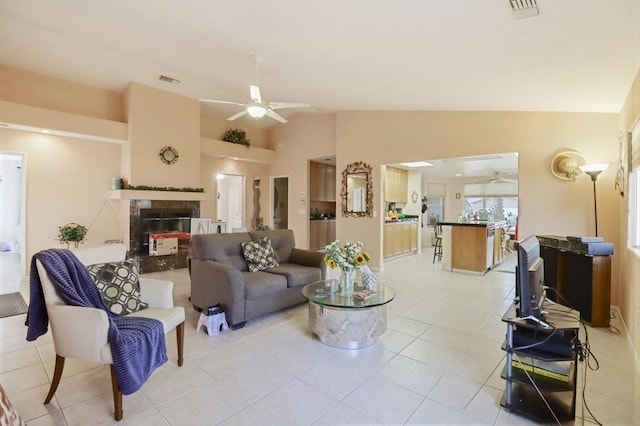 tiled living room featuring lofted ceiling, ceiling fan, and a high end fireplace