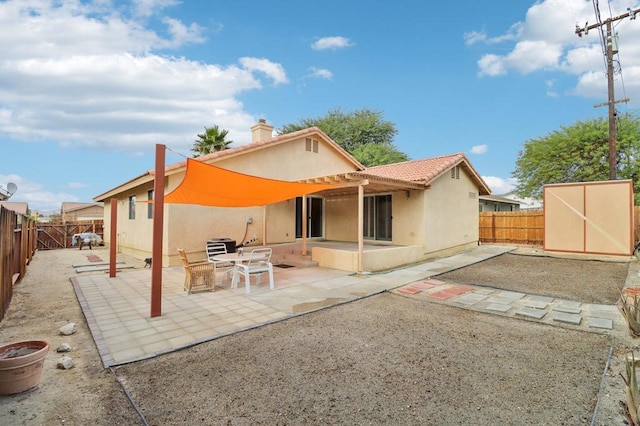 back of property featuring a shed and a patio area