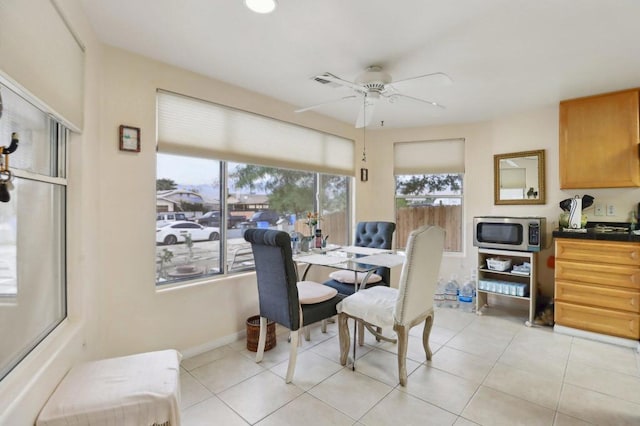 tiled dining space with ceiling fan