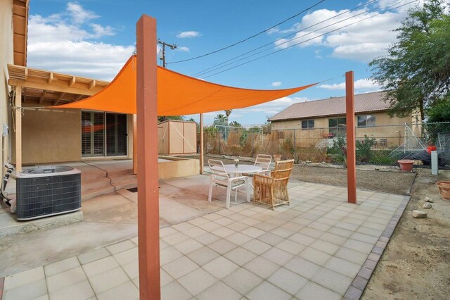 view of patio / terrace with central AC and a storage shed