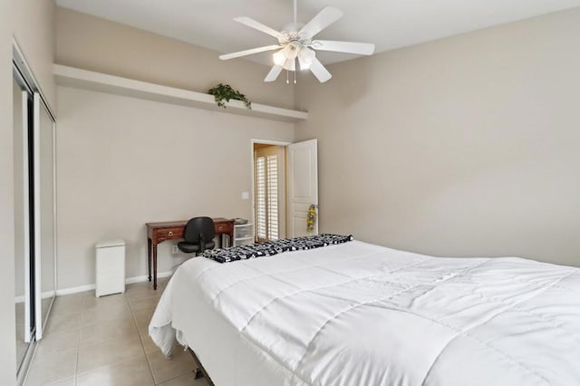 tiled bedroom featuring ceiling fan and a closet