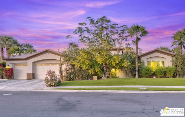 view of front of property with a yard and a garage