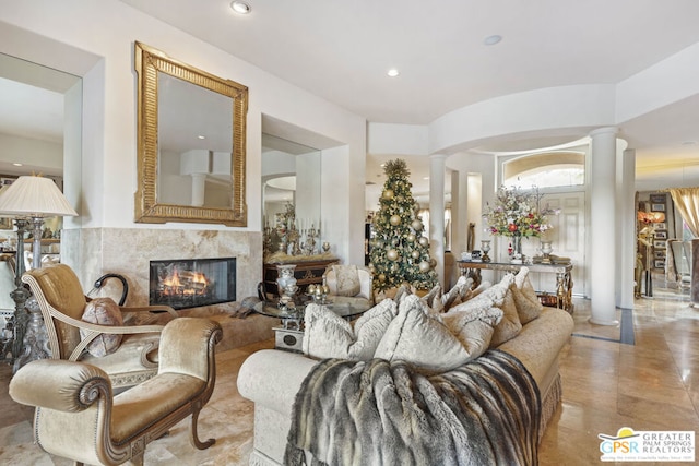 living room featuring a fireplace and decorative columns