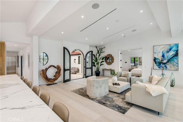 living room featuring lofted ceiling and light hardwood / wood-style flooring