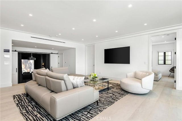 living room featuring light wood-type flooring and crown molding