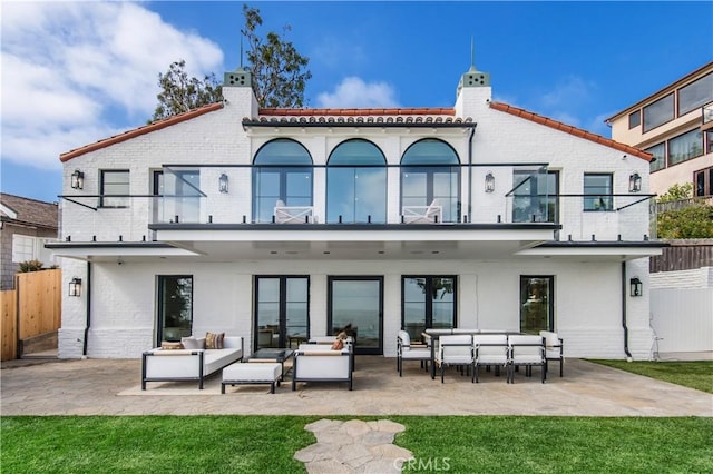 rear view of property with a balcony, a patio area, and an outdoor hangout area