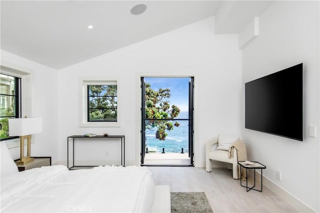 bedroom featuring lofted ceiling, access to exterior, and light hardwood / wood-style flooring