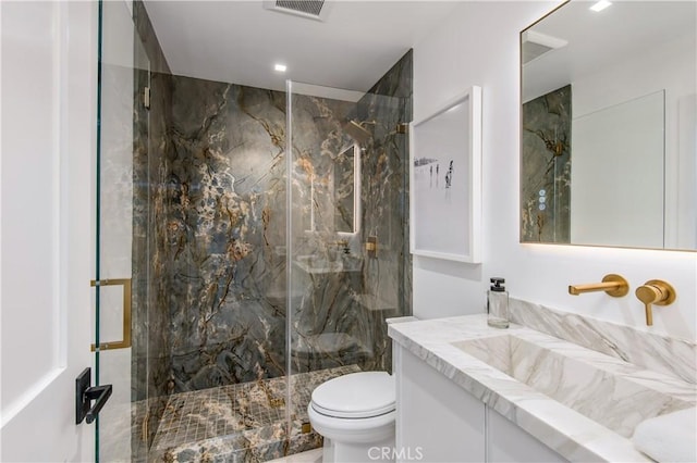 bathroom featuring toilet, vanity, and an enclosed shower