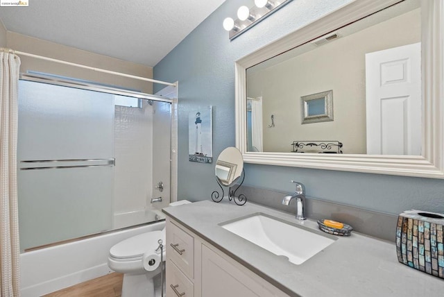 full bathroom with hardwood / wood-style flooring, enclosed tub / shower combo, vanity, toilet, and a textured ceiling