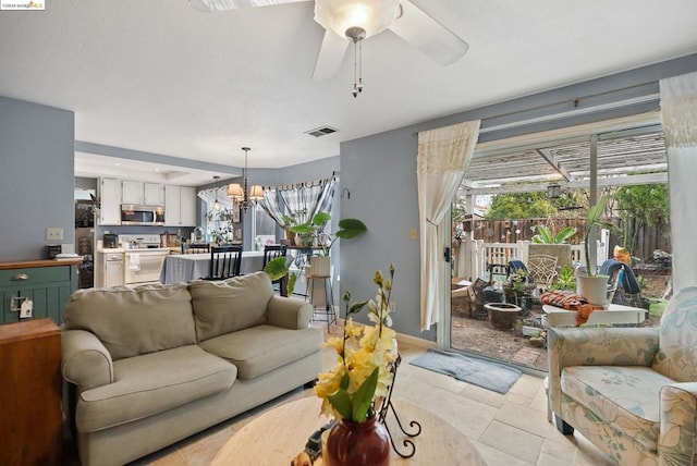 living room featuring ceiling fan with notable chandelier